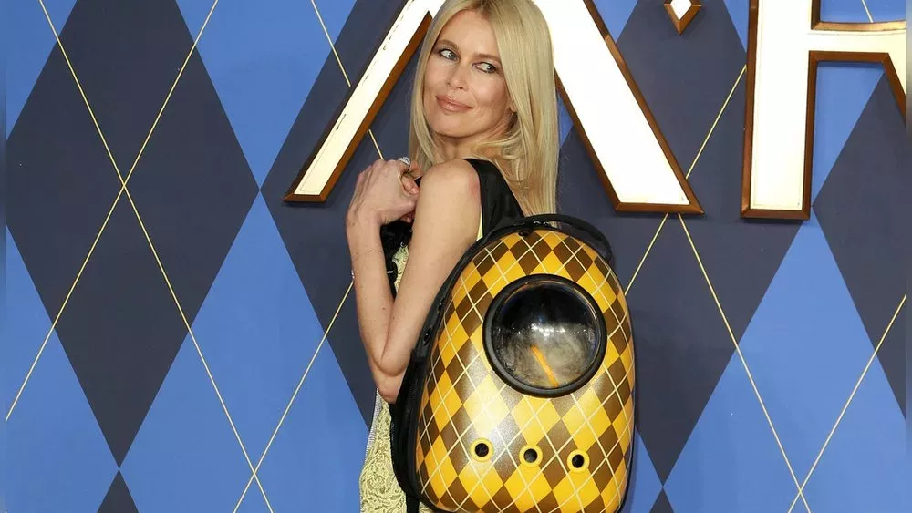 Claudia Schiffer posiert mit Katze im Rucksack auf dem roten Teppich