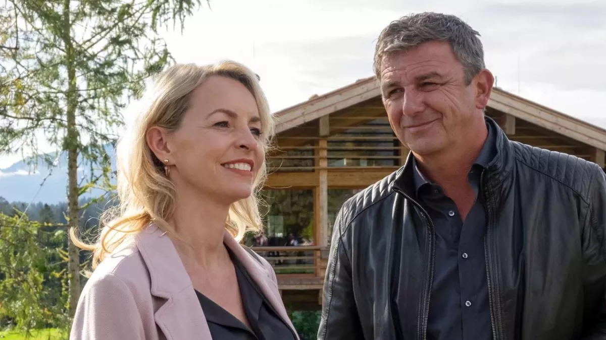 "Der Bergdoktor: Bittere Tränen": Martin (Hans Sigl) steht nah bei Franziska (Simone Hanselmann) vor einem Holzhaus und lächelt sie an.
