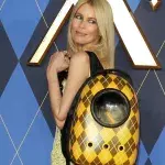 Claudia Schiffer posiert mit Katze im Rucksack auf dem roten Teppich