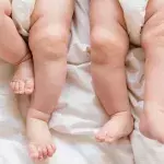 Zwei Säuglinge liegen auf einer Decke