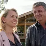 "Der Bergdoktor: Bittere Tränen": Martin (Hans Sigl) steht nah bei Franziska (Simone Hanselmann) vor einem Holzhaus und lächelt sie an.