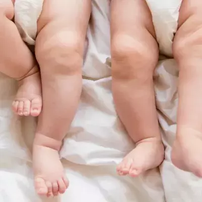 Zwei Säuglinge liegen auf einer Decke